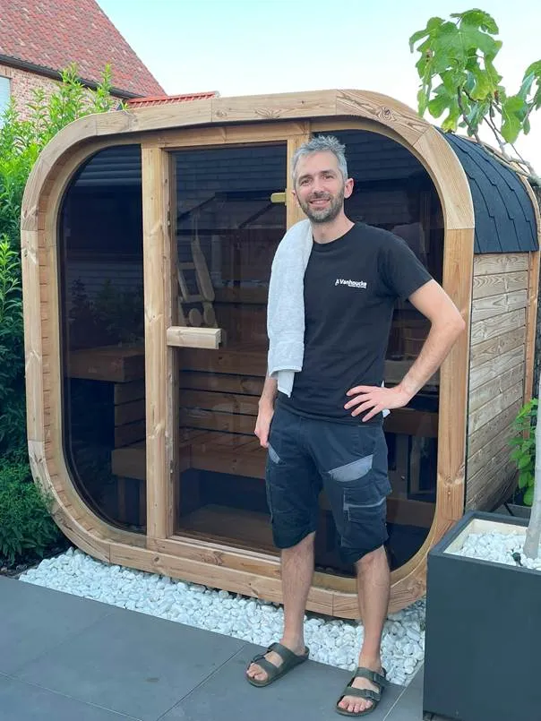 Maarten bij zijn zelfgebouwde Thermowood Cube sauna in de tuin