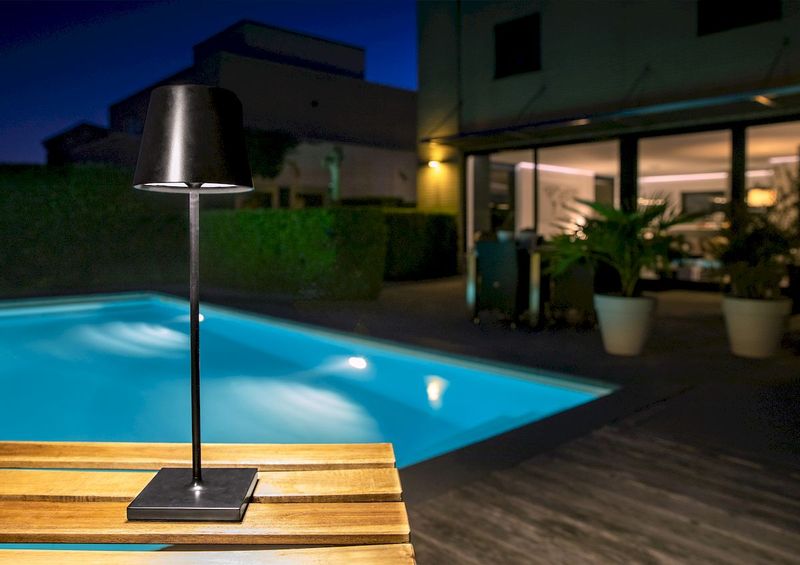 Lucide Justin led tafellamp - Zwart - op tuintafel bij zwembad
